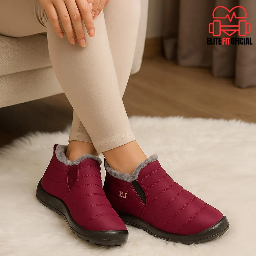 Bota feminina vinho peluciada sendo usada em ambiente interno, perfeita para conforto em casa.